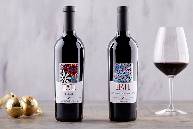 Primary Colors 4th Quarter 2022 Club Shipment. 2019 Eighteen Seventy-Three Cabernet Sauvignon & Coeur Hall Cabernet Sauvignon bottleshots with wine glass to the right with wine in it image